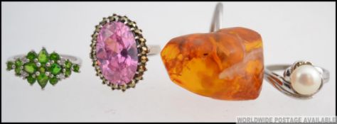 A collection of four silver ( 925 ) rings to include amber set ring, cluster ring,