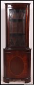 A Regency style mahogany inlaid corner cabinet.