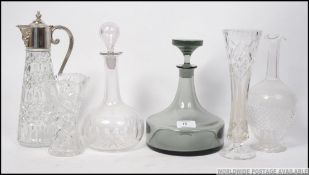 A collection of cut glass decanters to include one by Dartington along with a silver plated claret