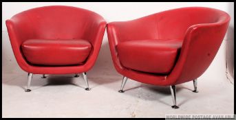 A pair of retro style chrome and red vinyl upholstered tub chairs.