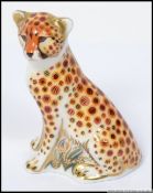 A Royal Crown Derby paperweight Cheetah Cub with gold stopper.