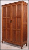 A 1930's Oak double wardrobe having plinth base with twin doors and flared top above.