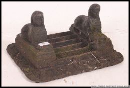 A Victorian cast iron painted bootscrape with grated base and recumbant lions to either side.
