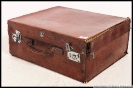 An early 20th century good quality leather suitcase with hinged top having central carry handle