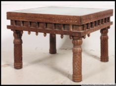 A 20th century Indian hard wood and brass studded square coffee table, having drop in glass panel,