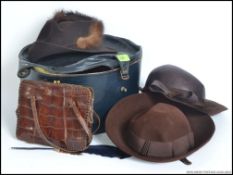 A vintage hat box with 3 vintage hats together with a vintage crocodile handbag.