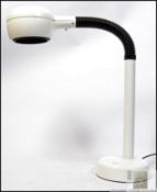 A retro desk lamp, finished in white, enameled lamp shade and base, joined by a black,