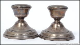 A pair of silver hallmarked candle sticks of miniature form with makers marks for Broadway and CO