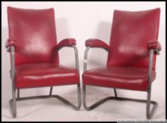 A pair of 1950's retro tubular metal and red vinyl armchairs.