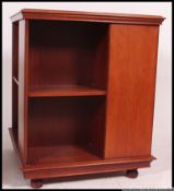 A large mahogany revolving bookcase from the 20th century having swivel base with sectional upright