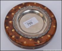 A continental silver wine coaster having marks to the verso set within a leather base with gilt