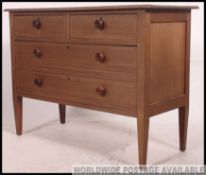 An Edwardian mahogany inlaid chest of drawers being raised on squared legs with a series of short