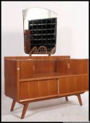 A retro 1960's teak dressing table chest being raised on angled legs with drawers and unusual upper
