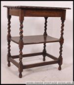 A 1920's carved oak barleytwist side table having scalloped edge table top with secondary tier