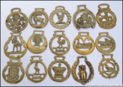 A collection of 19th and 20th century horse brasses to include military, horseshoe, jubilee, Stag,