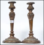 A pair of large copper silver plated candlesticks of eclesiastical form with single scones on