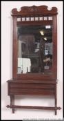 A Victorian wall mirror with bevelled plate glass mirror on mahogany frame with hinged cabinet