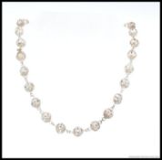 A decorative silver metal ( tests as silver ) fret work ball finial necklace 45cm in length,