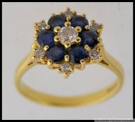 An 18ct gold diamond and sapphire set ladies flower Tier cluster ring.