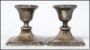 A pair of silver hallmarked stub candlesticks, each with single sconces to each.