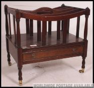 An Antique Regency style mahogany canterbury. Raised on turned legs with brass castors.