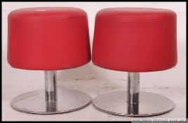 A pair of retro chrome and red vinyl upholstered stools having tulip style chrome bases