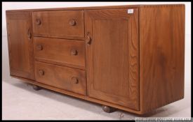 A stunning Ercol Windsor pattern low beech and elm sideboard.