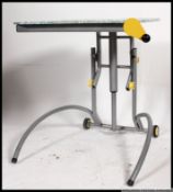 An unusual 1980's ' Memphis ' style adjustable computer work table being raised on tubular frame.
