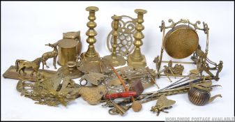 A large collection of brasswares to include candlesticks, figurines, trivets, gong, snuffer,