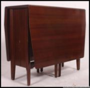 A 1970's retro teak wood drop leaf harvest dining table raised on angular legs with large table top