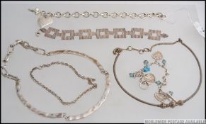 A collection of white metal silver necklaces and bracelets, each of different designs,