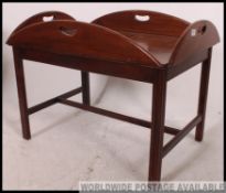 A 20th century mahogany antique style folding gallery butlers raised on squared legs base,