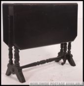 A late Victorian ebonised aesthetic movement drop leaf sutherland occasional table.