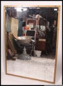 A large bevel edge wall mirror of rectangular form having solid brass frame with aged mirror to