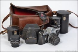 A vintage Pentax Ashai 35mm camera along with spare lenses all cased along with a camera bag