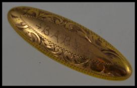 A 9ct gold lozenge shaped brooch being chase decorated with pin to verso. Total weight 2.