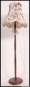 A mid 20th century turned oak standard lamp of usual form complete with a chintzy shade