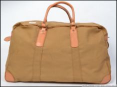 A vintage mid century canvas military holdall bag, having a full length zip across the top,