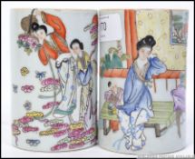 A fabulous pair of Chinese famille rose ceramic brush pots having decorative family scenes /
