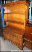 A Stag mahogany welsh style dresser having drawers and cupboards to the base with upright gallery