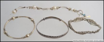 A collection of 4 silver bracelets and bangles to include bar set, ball finial spacer set,