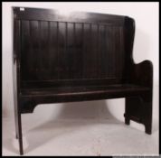 An early 20th century jacobean revival oak high back hall settle pew.