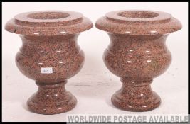 A pair of antique pink marble porphyry urns.