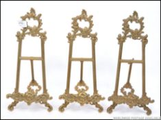 A group of three contemporary decorative brass easel picture stands.