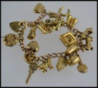 A 9ct gold charm bracelet having 19 char