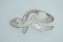 A 1950s German 935 silver brooch in a filigree ribbon design with roller clasp. Marked 935.