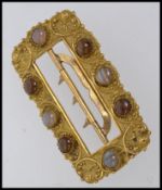 A large Victorian pinchbeck buckle set with cabochon agate stones in a rococo ground with a three