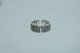 A 925 silver band ring set with marcasite within a pierced Greek Key design. Size M. Weight 7.4g.