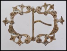 A large Victorian white metal belt buckle clip set with paste stones in pierced elaborate rococo