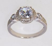 A 925 silver ring set with a central CZ with a halo gallery and pave set CZ shoulders. Size P.